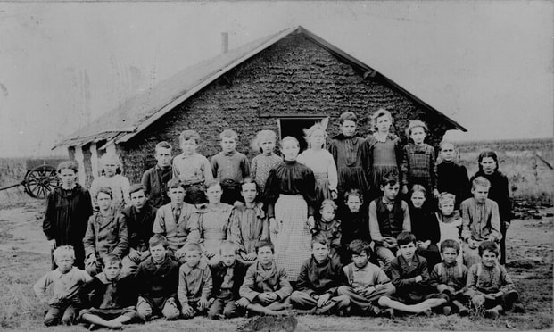 Teacher and children in front of sod schoolhouse. Woods Co., Oklahoma Territory, ca. 1895. 48-RST-7B-97. National Archives, Washington DC.